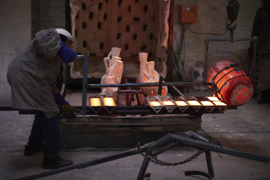 South Africa, Cape Town, Molten bronze being poured into shells for casting