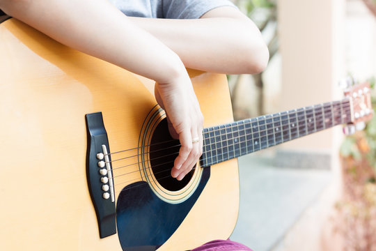 Woman's hands with acoustic guitar in relax post