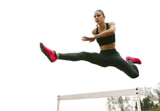 Athlete woman jumping in a running track
