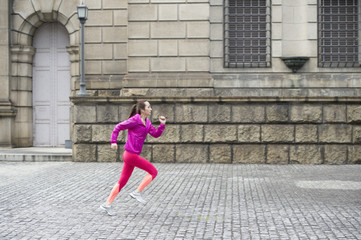 Fototapeta na wymiar Young woman is running wearing sportswear