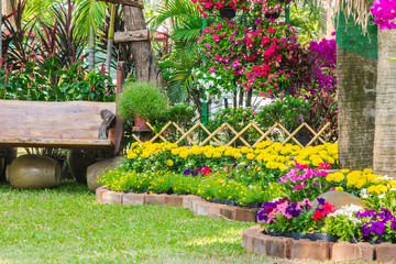 Wood chair in the flowers garden./ Panorama landscape flower garden with lots of colorful blooms and wood chair.
