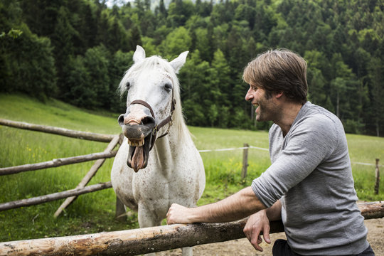 Germany, Bavaria, Bad Toelz, man with horse at fence
