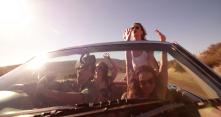 Hipster friends carefree in vintage convertible car during road trip - Powered by Adobe