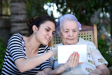 girl show tablet to grandma