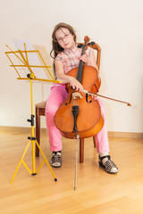 Pretty young girl practice playing cello © idea_studio