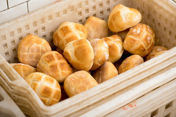 Plastic basket with freshly baked bread rolls