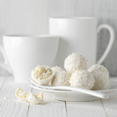 Coconut candies pile in white plate and cups