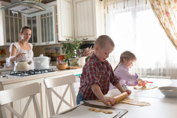 Obraz na płótnie Canvas Mother with three kids cooking biscuits casual lifestyle photo