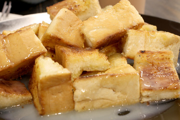 Bread toast with butter and condensed milk in a plate, select focus