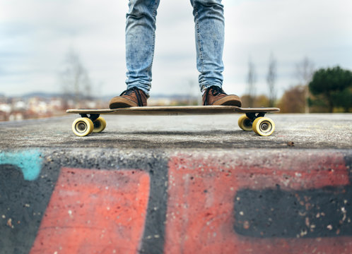 Legs of young man standing on his skateboarder