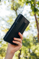 Female hand holding an e-book in the cover on the background of