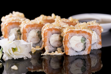 Sushi Roll with salmon and crab meat over  black background with