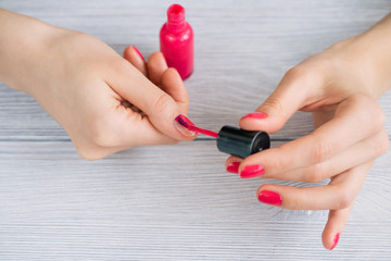 Women's hands painted nails with red lacquer, close-up