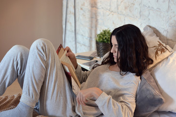 woman reading a book in bed