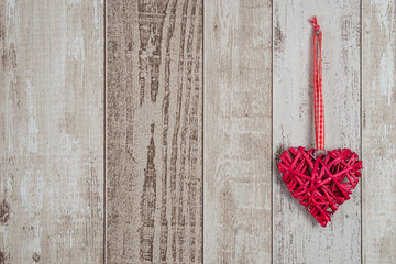 Red wood heart hanging on rustic wooden background