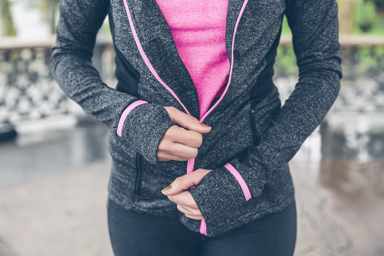 Woman closing zipper of sportive jacket