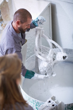 South Africa, Cape Town, Craftspeople preparing ceramic shell around casting mold