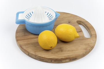 Two lemon and strainer on a wooden board
