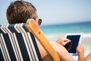 Man relaxing and using tablet - Powered by Adobe