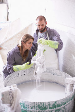 South Africa, Cape Town, Craftspeople preparing ceramic shell around casting mold