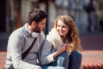 Young couple in love in town sitting on stairs