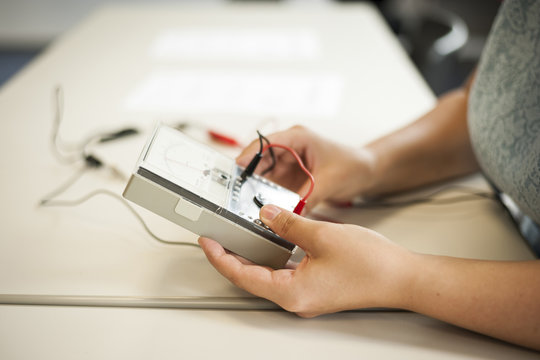 Vocational school student in physics class holding measuring device