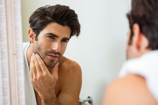 Man checking his stubble in bathroom