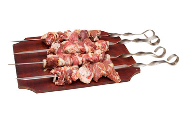 barbecue, raw juicy slices of meat on skewers with sauce on kitchen board