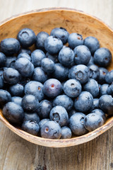 Blueberries in a bowl on a wooden table.