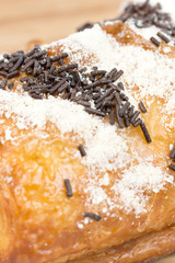Chocolate croissant on a wooden board isolated on white