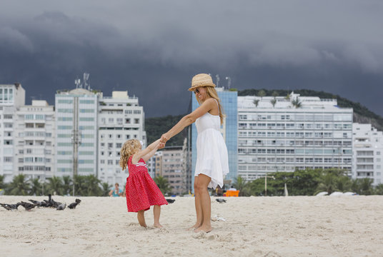 Brazil, Rio de Janeiro, mother and daughter playing on Copacabana beach