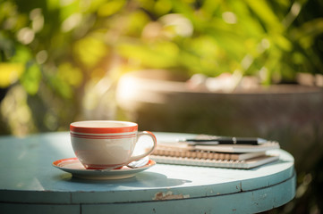 coffee cup with notebook on cafe table