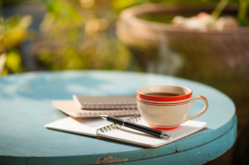 Notenook and coffee cup on wood table
