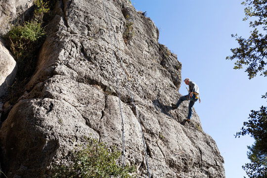 Spain, Tarragona, Siurana, climber climbing a stone wall