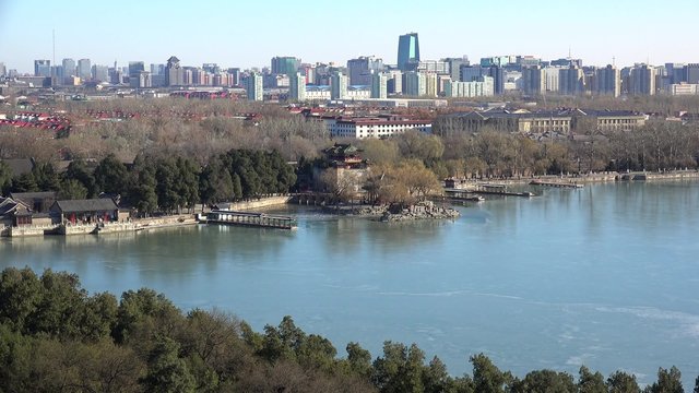 East causeway of the iced Kunming lake (Summer Palace) with the Beijing skyline on background.