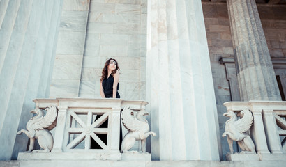 Fototapeta na wymiar young lady in black dress on stone balcony 