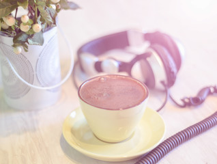 headphones and cup with coffee on the colorful tablecloth