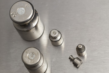 Obraz premium Plummets set on weigh-scales. Jewelry workplace on metal background with copy space for text.