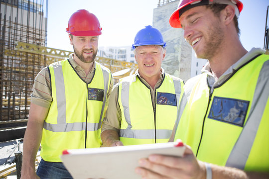Three construction workers with digital tablet in construction site