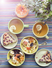breakfast with cereal mush, fruits, pie and tea. On the colorful tablecloth.