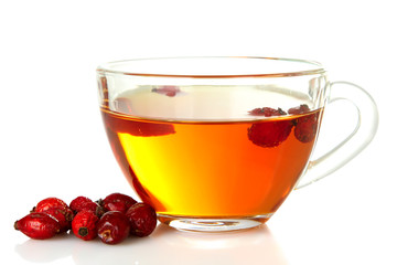 flavored green tea in transparent Cup with berries of wild rose isolated on white background
