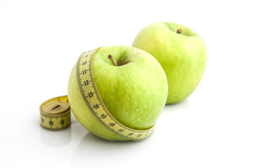 Green apple and measuring tape. Diet concept.
