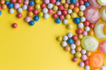 Obraz premium Candies colorful mix on yellow bright background with copy space