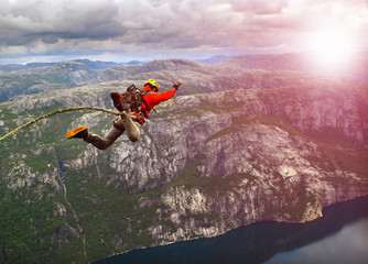 Young man jumping from a cliff into the abyss.