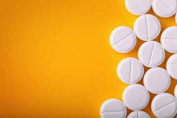 White medical pills on synthetic yellow background - obrazy, fototapety, plakaty