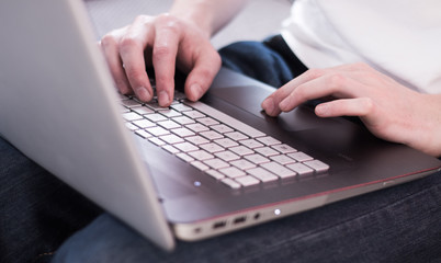 Laptop am Schoß, Tastatur und Männerhände