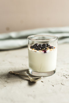 Glass 0f yogurt with muesli and black currants
