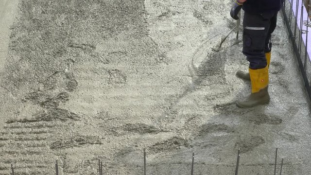 Construction worker during concrete pouring work at the construction site