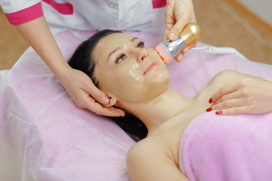 Young beautiful woman with dark hair gets procedure in the beauty salon