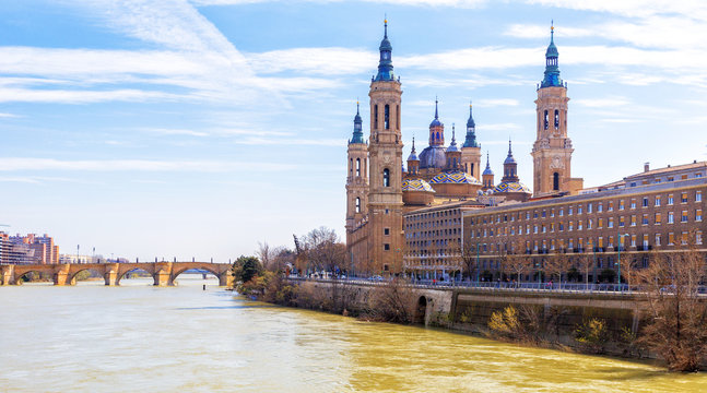 Ancient stone bridge and Cathedral from Ebro river. Zaragoza, Ar